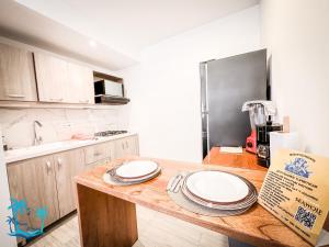 eine Küche mit einem Holztisch mit Tellern darauf in der Unterkunft Casa Turística Praia House in San Andrés