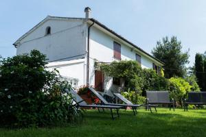 ein weißes Haus mit Bänken davor in der Unterkunft Casa Vacanze Cassero in Camerata Picena