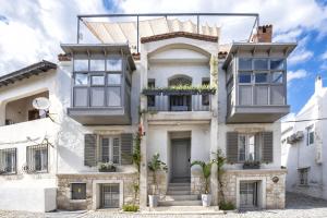 a house with white walls and windows at Blue Alle Alaçatı in Alaçatı