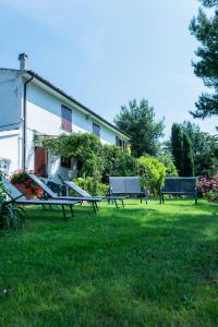 zwei Bänke im Gras vor einem Haus in der Unterkunft Casa Vacanze Cassero in Camerata Picena