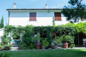 a white house with plants in front of it at Casa Vacanze Cassero in Camerata Picena