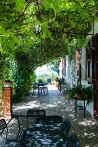 eine Außenterrasse mit Tischen, Stühlen und Bäumen in der Unterkunft Casa Vacanze Cassero in Camerata Picena