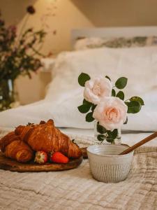 un tavolo con un piatto di cibo e un vaso di rose di Appartamento il Rosmarino a Portoferraio
