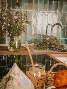 a counter with a table with flowers in a vase at Appartamento il Rosmarino in Portoferraio