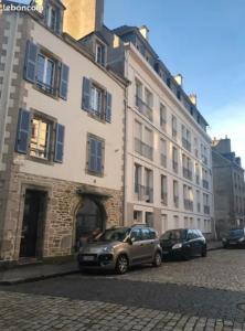 two cars parked in front of a large building at Location 2 pers centre historique de quimper in Quimper