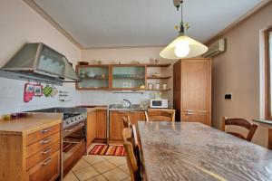 eine Küche mit Holzschränken und einem Holztisch in der Unterkunft Casa Patrizia by PosarelliVillas in Loro Ciuffenna