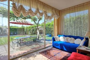 ein Wohnzimmer mit einem blauen Sofa und einem großen Fenster in der Unterkunft Casa Patrizia by PosarelliVillas in Loro Ciuffenna