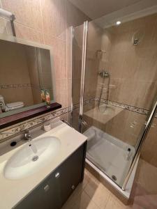 a bathroom with a sink and a shower at Piso vacacional con terraza panorámica a la ría. in Viveiro
