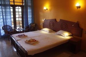 Un dormitorio con una cama grande con dos platos de comida. en Anitha's Garden Stay, en Kovalam