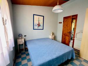 a bedroom with a bed with a blue bedspread at Bilocale a due passi dalla piazza di Rena Majore in Rena Majore