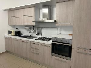 uma cozinha com armários de madeira e um forno com placa de fogão em Typical one bedroom apartment in Turin center em Turim