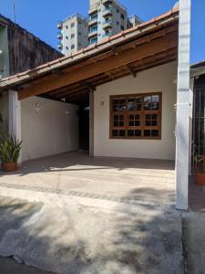 a house with a wooden roof and a patio at Praia litoral norte SP 70 m praia in Caraguatatuba