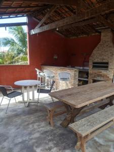 a patio with a table and chairs and a fireplace at Praia litoral norte SP 70 m praia in Caraguatatuba
