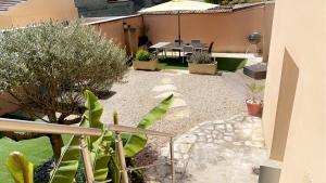 un jardín con plantas y un patio con mesa. en Maison entière avec cour dans le Chablisien, en Villy