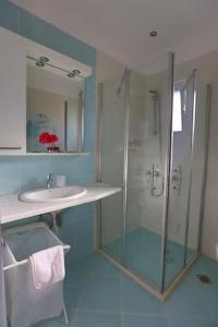 a bathroom with a glass shower and a sink at Villa Andromeda in Sivota