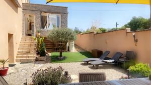 un pequeño patio trasero con 2 sillas y un jardín en Maison entière avec cour dans le Chablisien, en Villy