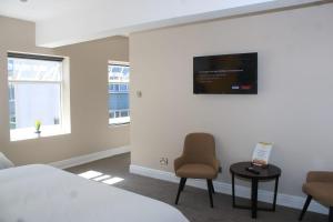 a bedroom with a bed and a tv on the wall at Fenwick Sunrise Hotel in Liverpool