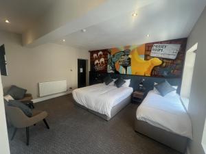 a hotel room with two beds and a painting on the wall at Fenwick Sunrise Hotel in Liverpool