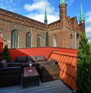 a patio with couches and a table in front of a building at Stay inn Hotel Gdańsk in Gdańsk