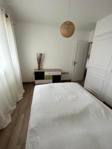 a white bedroom with a large white bed in it at Appartement Presqu île de Giens in Hyères