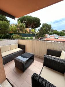 a patio with couches and a table and chairs at Appartement Presqu île de Giens in Hyères