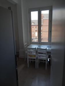 Belle Chambre pour une personne في رووين: غرفة طعام مع طاولة وكراسي ونافذة