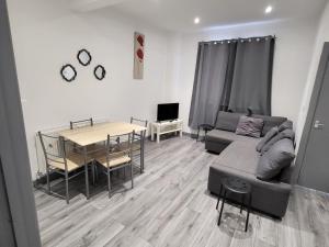 a living room with a couch and a table at Vetrelax Southend Apartment in Westcliff-On-Sea