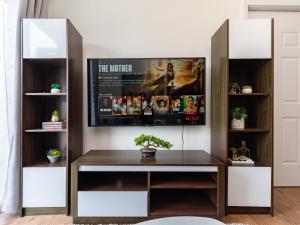 een bureau in een kamer met een tv aan de muur bij Amani 237, 3 Minutes from the Airport, Free Netflix, Free Wifi in Pusok