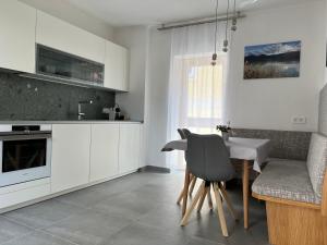 黑馬戈爾的住宿－das STOCKSTAN，厨房配有白色橱柜、桌子和椅子