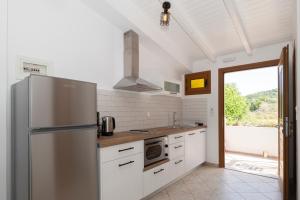 uma cozinha com um frigorífico de aço inoxidável e uma janela em Asterias Studios Finikounda em Finikounta