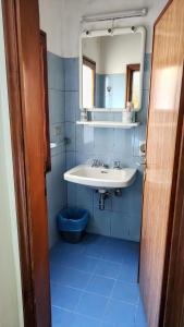 een blauwe badkamer met een wastafel en een spiegel bij Hotel Ristorante Miramonti in Consuma