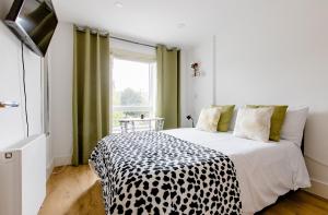 a bedroom with a black and white bed with a window at Charlotte Double Room in London