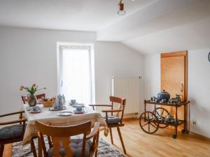 ein Esszimmer mit einem Tisch, Stühlen und einem Fenster in der Unterkunft Gästehaus Tannenberg in Bayerisch Gmain