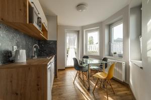 a kitchen with a glass table and chairs at AQUA in Karwia