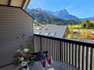 a balcony with a table with a view of mountains at Alpenglück-Garmisch in Garmisch-Partenkirchen