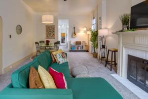 ein Wohnzimmer mit einer grünen Couch und einem Kamin in der Unterkunft Darling Pennsylvania Vacation Rental with Porch! in Pottstown