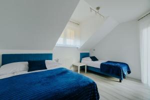 two beds in a room with blue and white at AQUA in Karwia