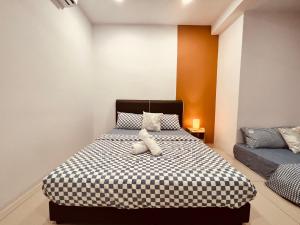 a bedroom with a bed with a black and white comforter at P1 PineComfyStay Waterpark 7pax Ipoh in Kampong Pinji