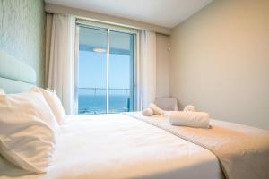 een slaapkamer met een bed met een groot raam bij Madeira Residence Apt. 80 in Funchal +28 foto's