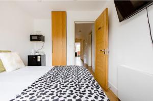 a bedroom with a bed with a black and white pattern at Charlotte Double Room in London