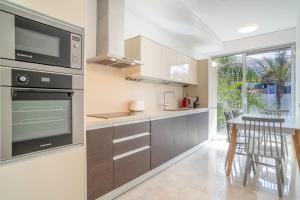 een keuken met roestvrijstalen apparatuur en een tafel bij Madeira Residence Apt. 80 in Funchal