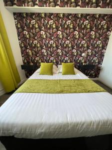 a bedroom with a large white bed with a wallpaper at Hotel Alpes Cevennes in Guilherand