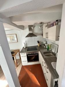 eine kleine Küche mit weißen Schränken und einem Waschbecken in der Unterkunft Gemütliche Ferienwohnung im Altbau in Goslar