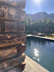 a brick wall next to a body of water at Le Hameau in Figari