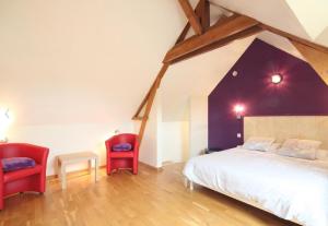 HeuquevilleにあるLes terrassesのベッドルーム1室(ベッド1台、赤い椅子2脚付)