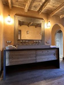 a bathroom with a large mirror and a wooden dresser at Le Hameau in Figari