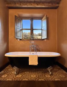 a bath tub in a bathroom with a window at Le Hameau in Figari