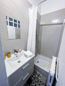ein weißes Bad mit einem Waschbecken und einer Dusche in der Unterkunft Fabre / Appartement central proche de la gare in Antibes