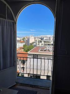 ein offenes Fenster mit einem Balkon und Stadtblick in der Unterkunft Fabre / Appartement central proche de la gare in Antibes