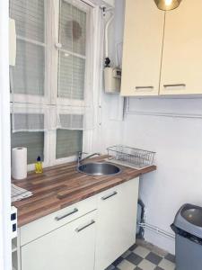 eine kleine Küche mit einem Waschbecken und einem Fenster in der Unterkunft Fabre / Appartement central proche de la gare in Antibes